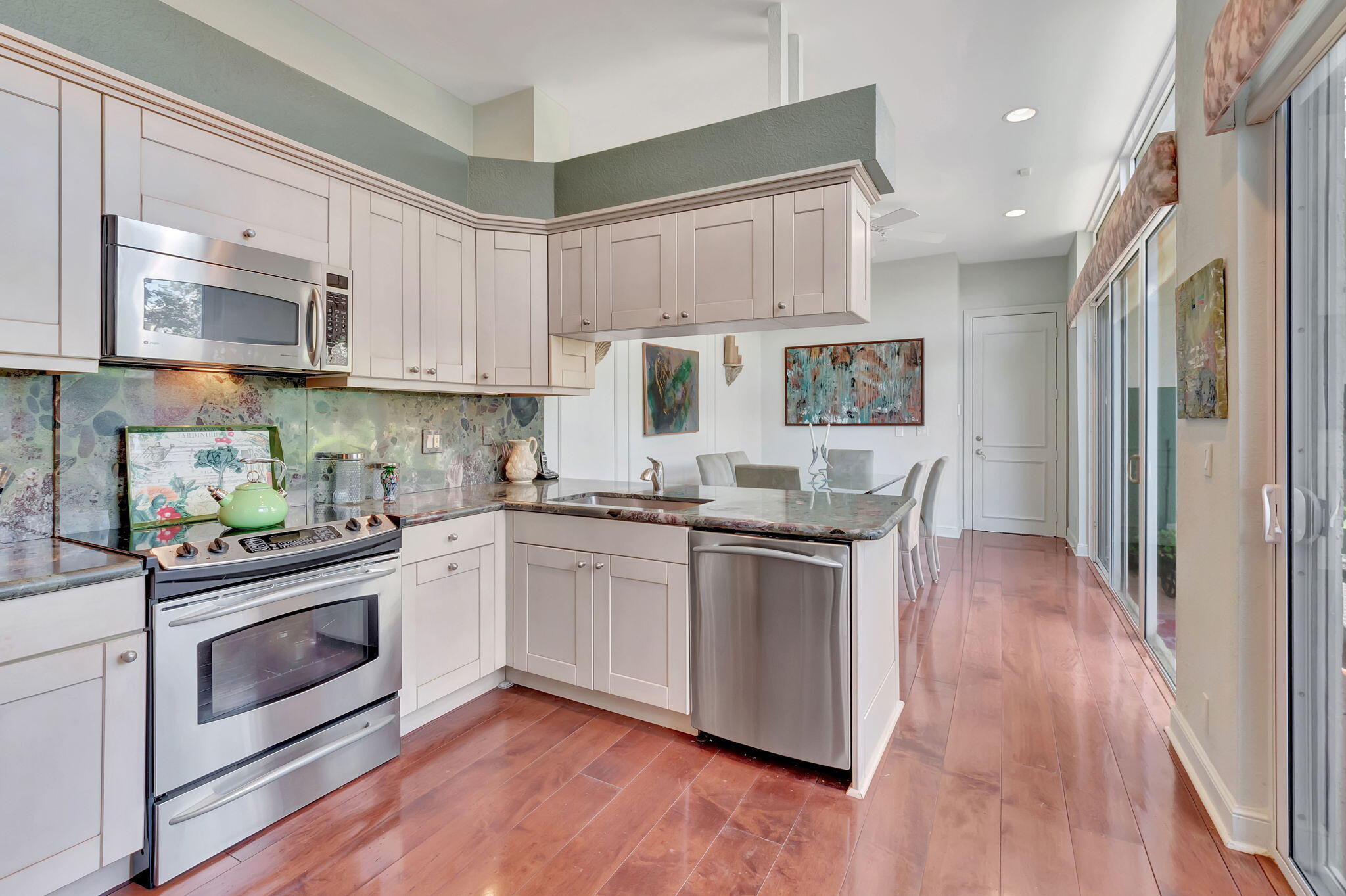2115 South Ocean Boulevard, Unit 14 Delray Beach, FL 33483 - Photo 19 of 56 a kitchen with stainless steel appliances granite countertop a stove and white cabinets