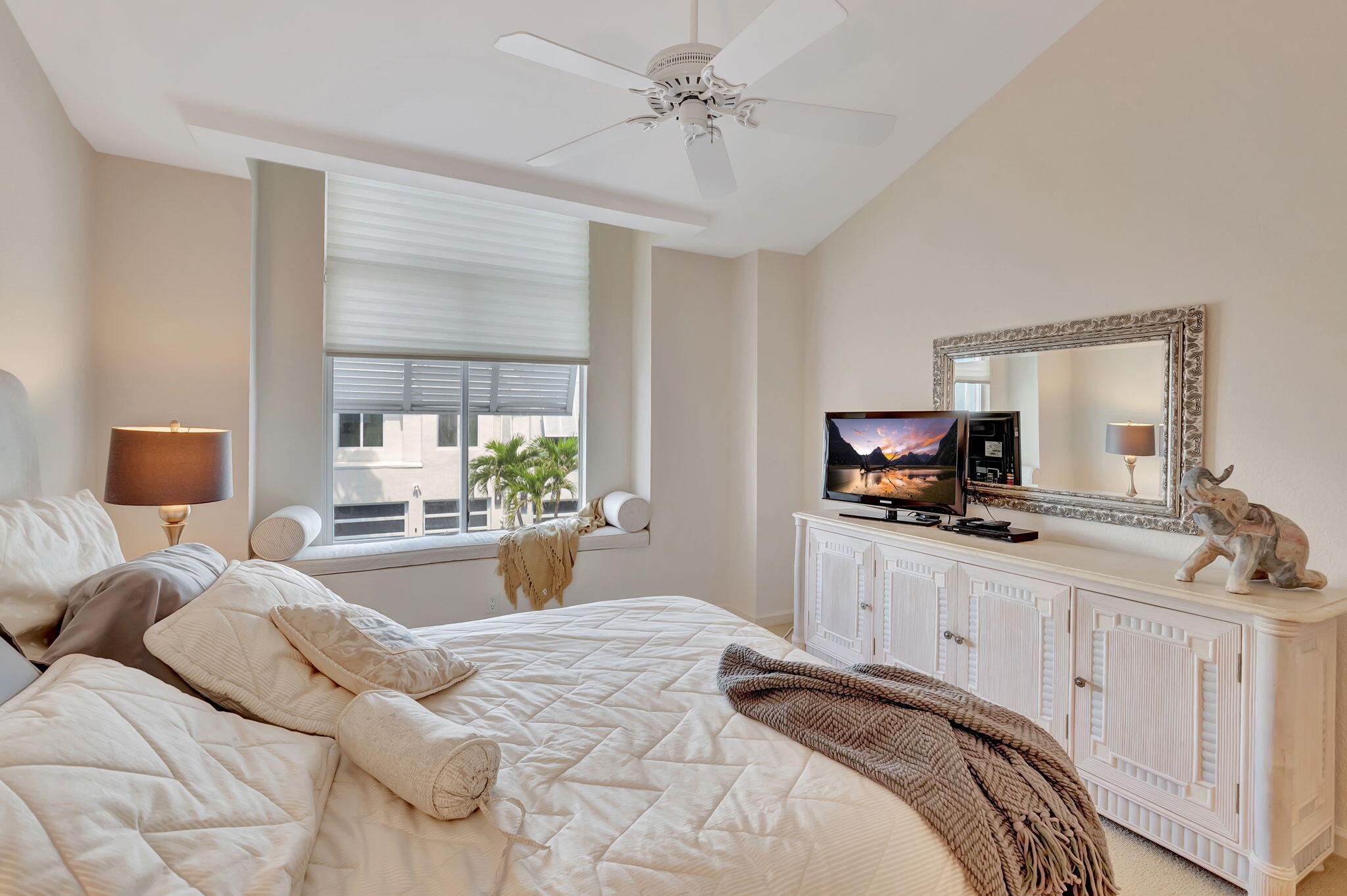 2115 South Ocean Boulevard, Unit 14 Delray Beach, FL 33483 - Photo 38 of 56 a bedroom with a bed a large window and flat screen tv