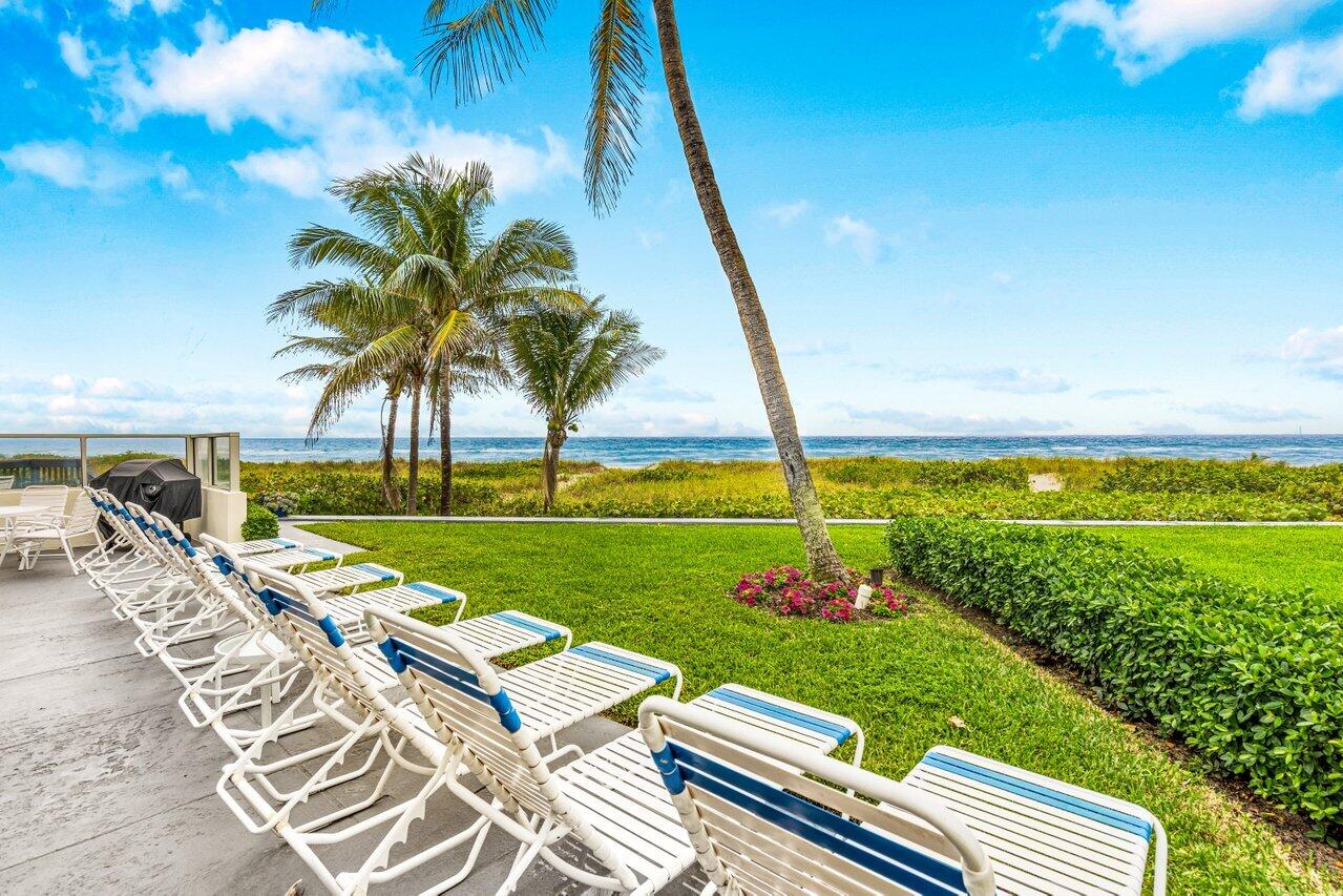 2115 South Ocean Boulevard, Unit 14 Delray Beach, FL 33483 - Photo 43 of 56 a view of a swimming pool with a garden and patio