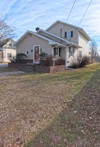 a view of a yard in front of a house with large trees