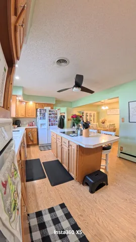 a kitchen with stainless steel appliances kitchen island granite countertop a sink and wooden floors