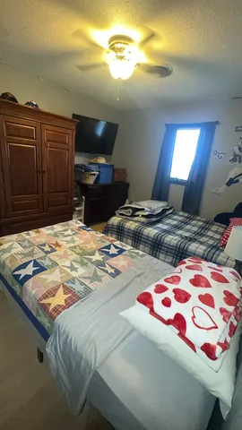 a spacious bedroom with a bed and a chandelier