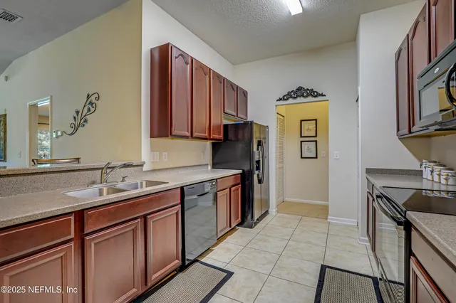 a kitchen with stainless steel appliances granite countertop a sink a stove and a refrigerator