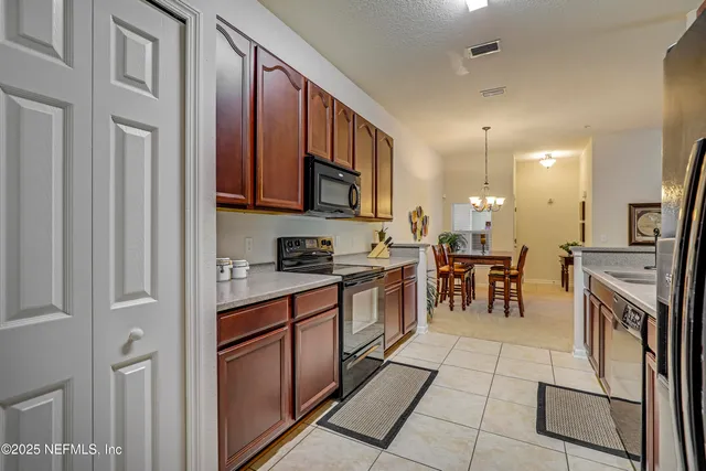 a kitchen with stainless steel appliances granite countertop a stove top oven a sink a dining table and chairs with wooden floor