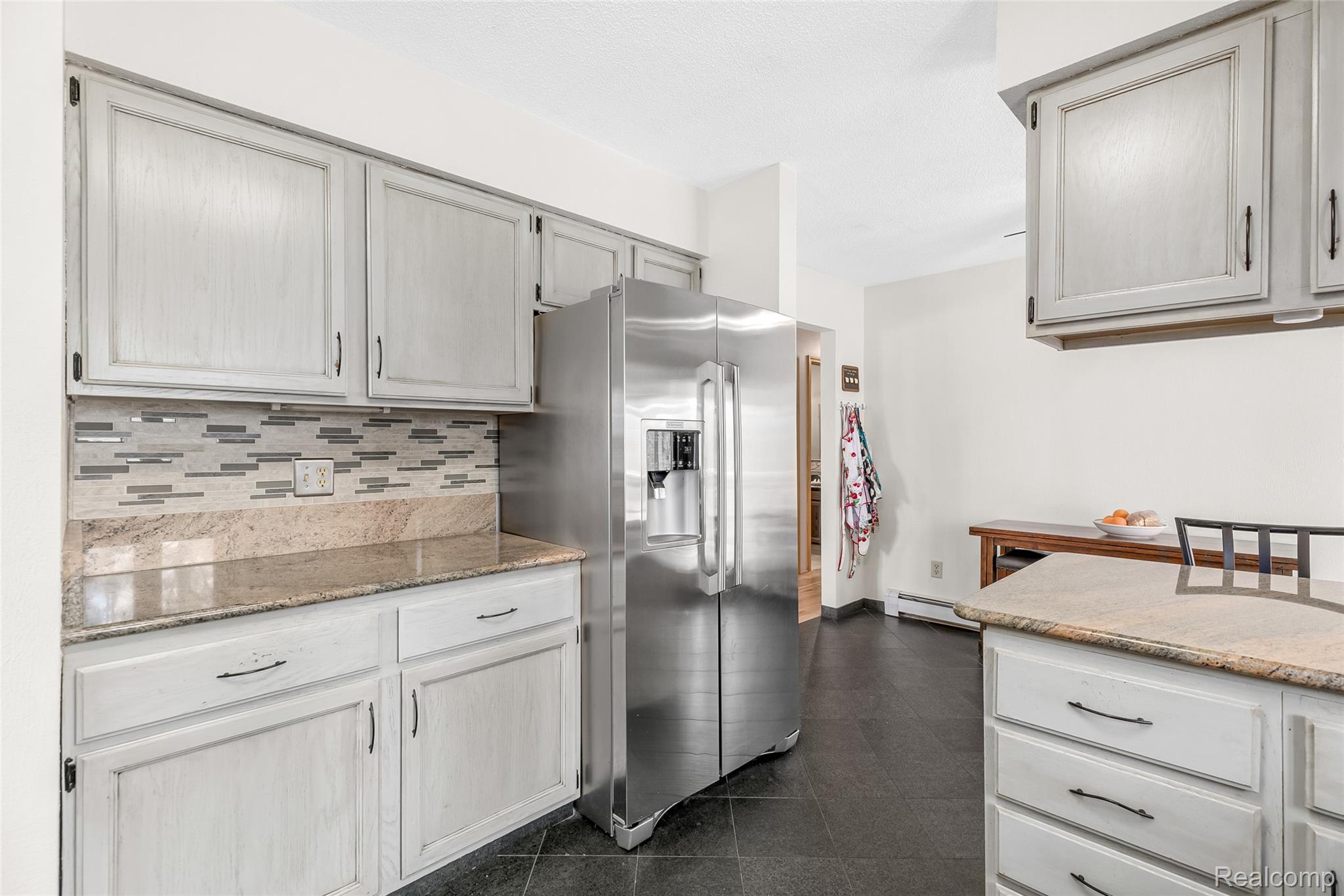 15395 Osius Road Chelsea, MI 48118 - Photo 11 of 55 Kitchen featuring light-toned cabinetry with dark hardware, granite countertops, and a tiled backsplash