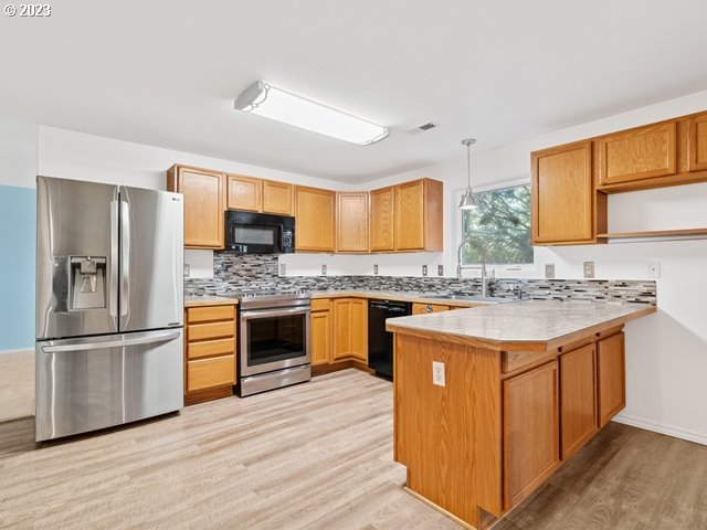 2488 Pheasant Ridge Street Umatilla, OR 97882 - Photo 15 of 40 a kitchen with stainless steel appliances granite countertop a sink stove and refrigerator