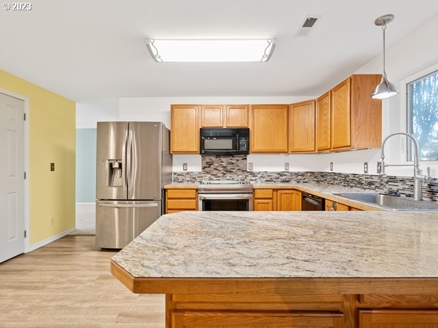 2488 Pheasant Ridge Street Umatilla, OR 97882 - Photo 8 of 40 a kitchen with stainless steel appliances granite countertop a sink a stove and refrigerator