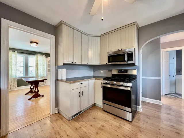 a kitchen with stainless steel appliances granite countertop a stove a sink and a microwave