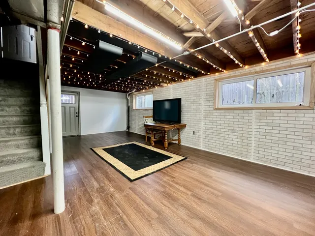 a living room with hard wood floors and a sink