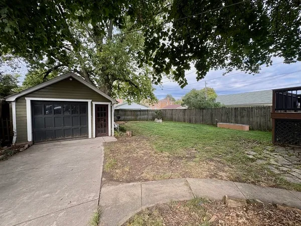 a view of a yard with a house and a large tree