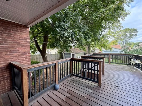 a view of deck with wooden floor and fence with a barbeque