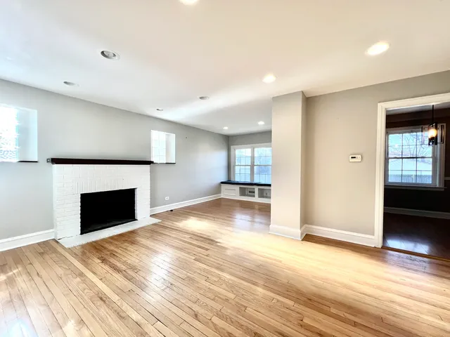 a view of a livingroom with wooden floor and a fireplace