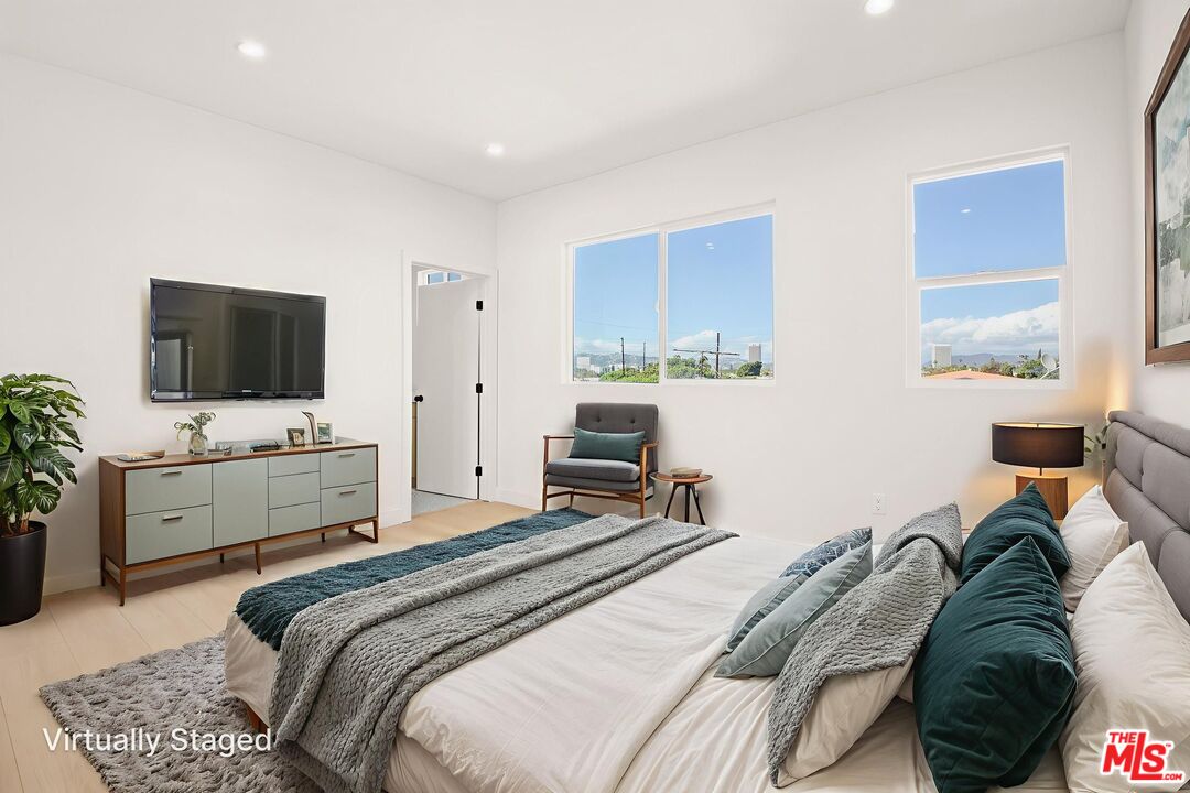 1707 South Burnside Avenue, Unit 1/2 Los Angeles, CA 90019 - Photo 24 of 30 a bedroom with a bed and a flat screen tv