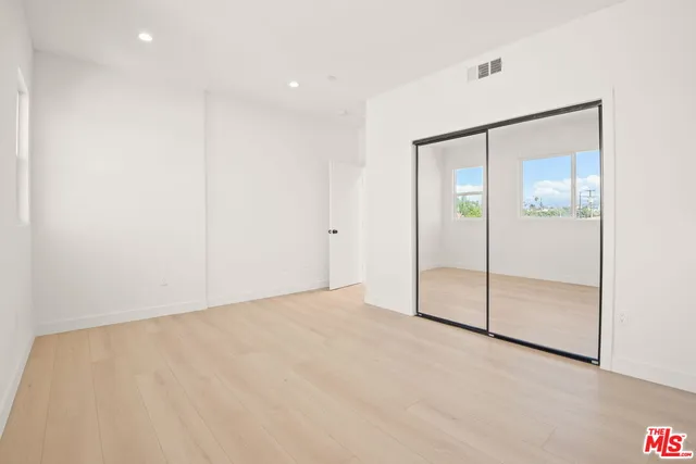 an empty room with closet and a glass door shower