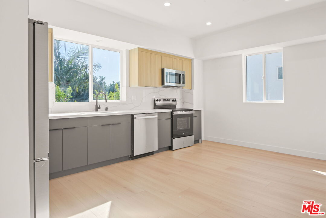1707 South Burnside Avenue, Unit 1/2 Los Angeles, CA 90019 - Photo 5 of 30 a kitchen with a sink stove and cabinets