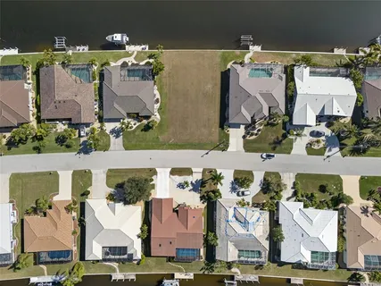 an aerial view of residential houses with outdoor space and parking
