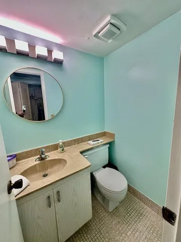 a bathroom with a toilet sink and mirror