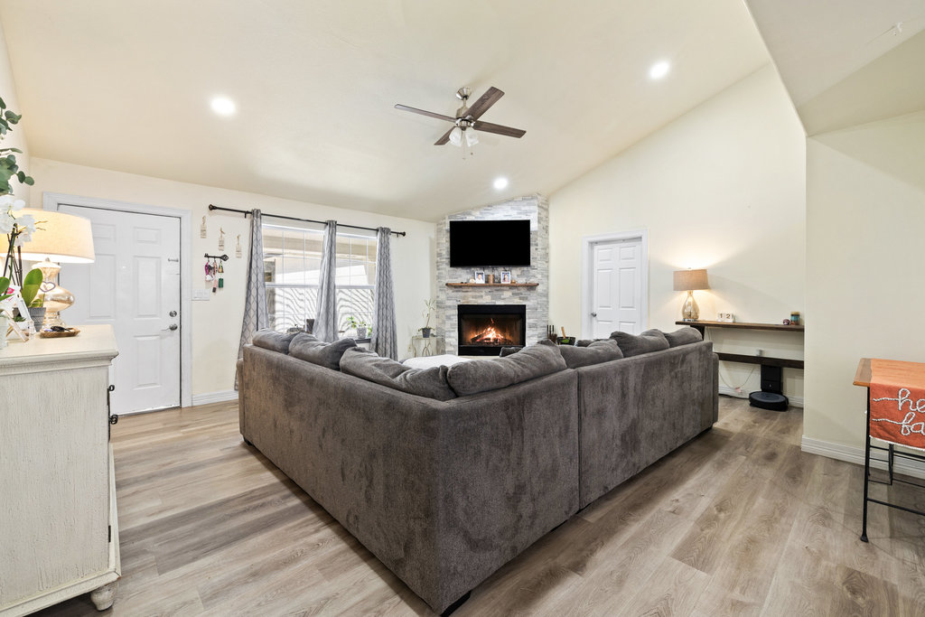 115 Rangeland Road Bastrop, TX 78602 - Photo 11 of 40 a living room with furniture a fireplace and a flat screen tv