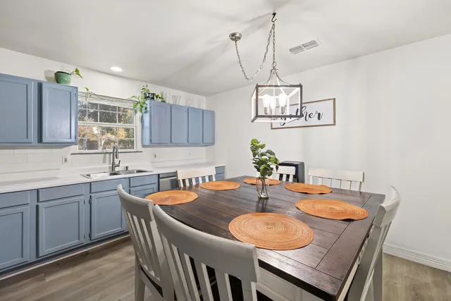 a dining room with wooden floor a sink and kitchen view
