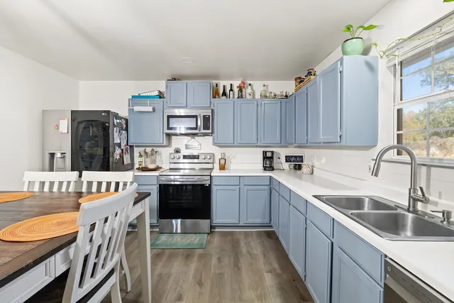 a kitchen with stainless steel appliances granite countertop a sink stove refrigerator and cabinets