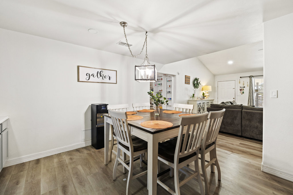 115 Rangeland Road Bastrop, TX 78602 - Photo 17 of 40 a view of a dining room and livingroom with furniture wooden floor a rug a chandelier