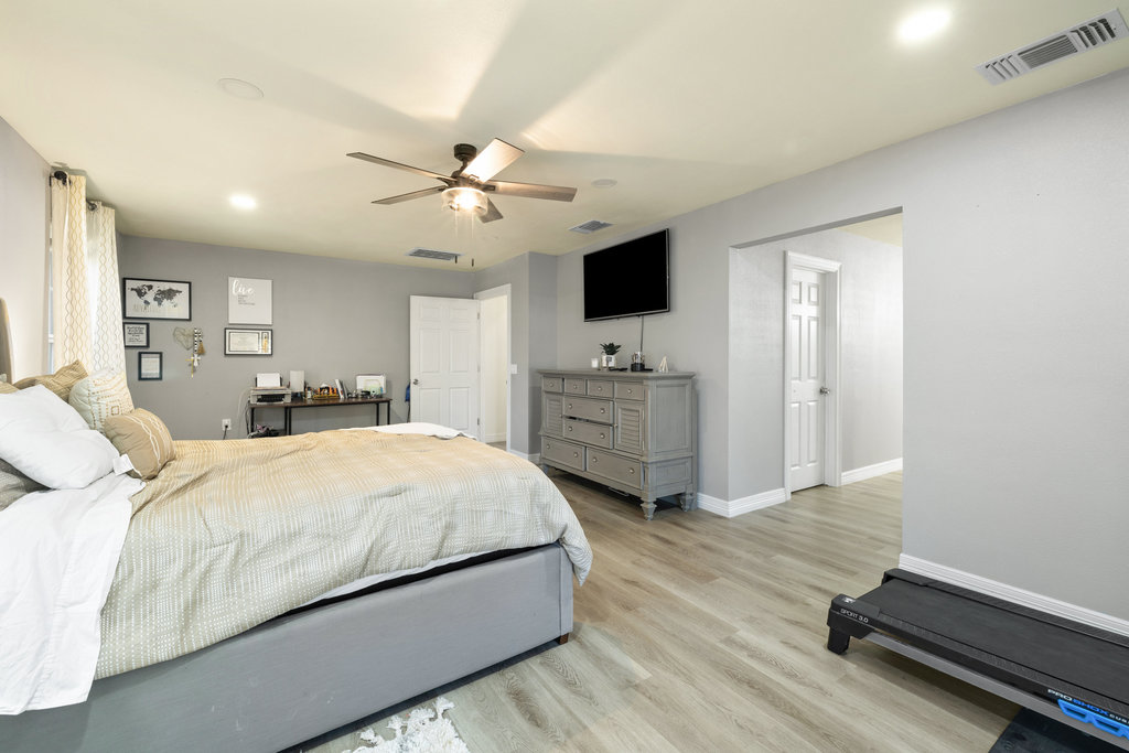 115 Rangeland Road Bastrop, TX 78602 - Photo 20 of 40 a spacious bedroom with a bed and a flat tv screen on dresser