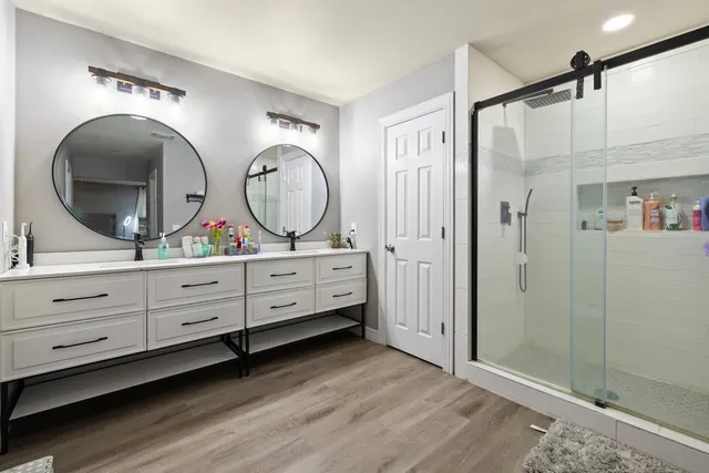 a bathroom with double vanity sink and a mirror