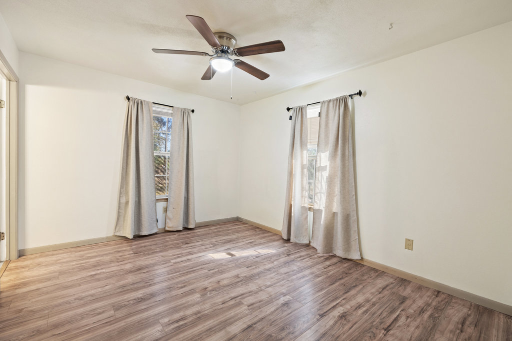 115 Rangeland Road Bastrop, TX 78602 - Photo 27 of 40 an empty room with wooden floor and windows