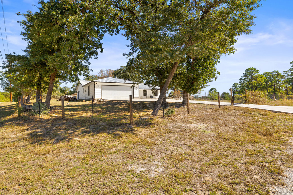 115 Rangeland Road Bastrop, TX 78602 - Photo 4 of 40 a view of a yard with plants and large trees