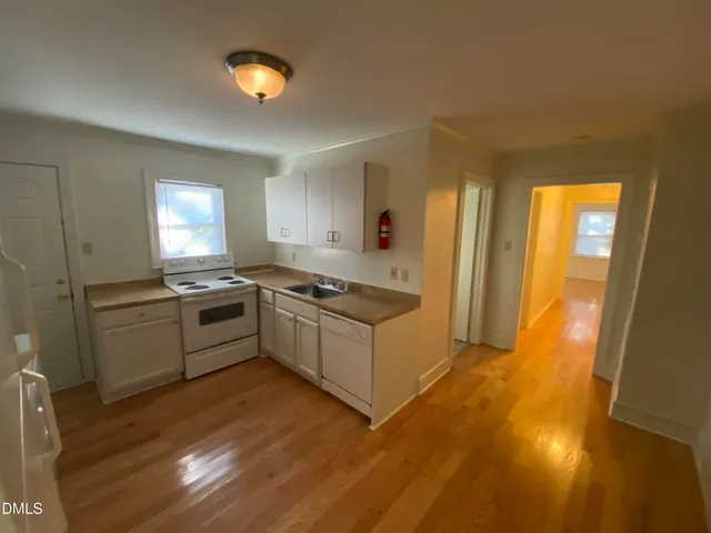 a view of an empty room with a chandelier fan