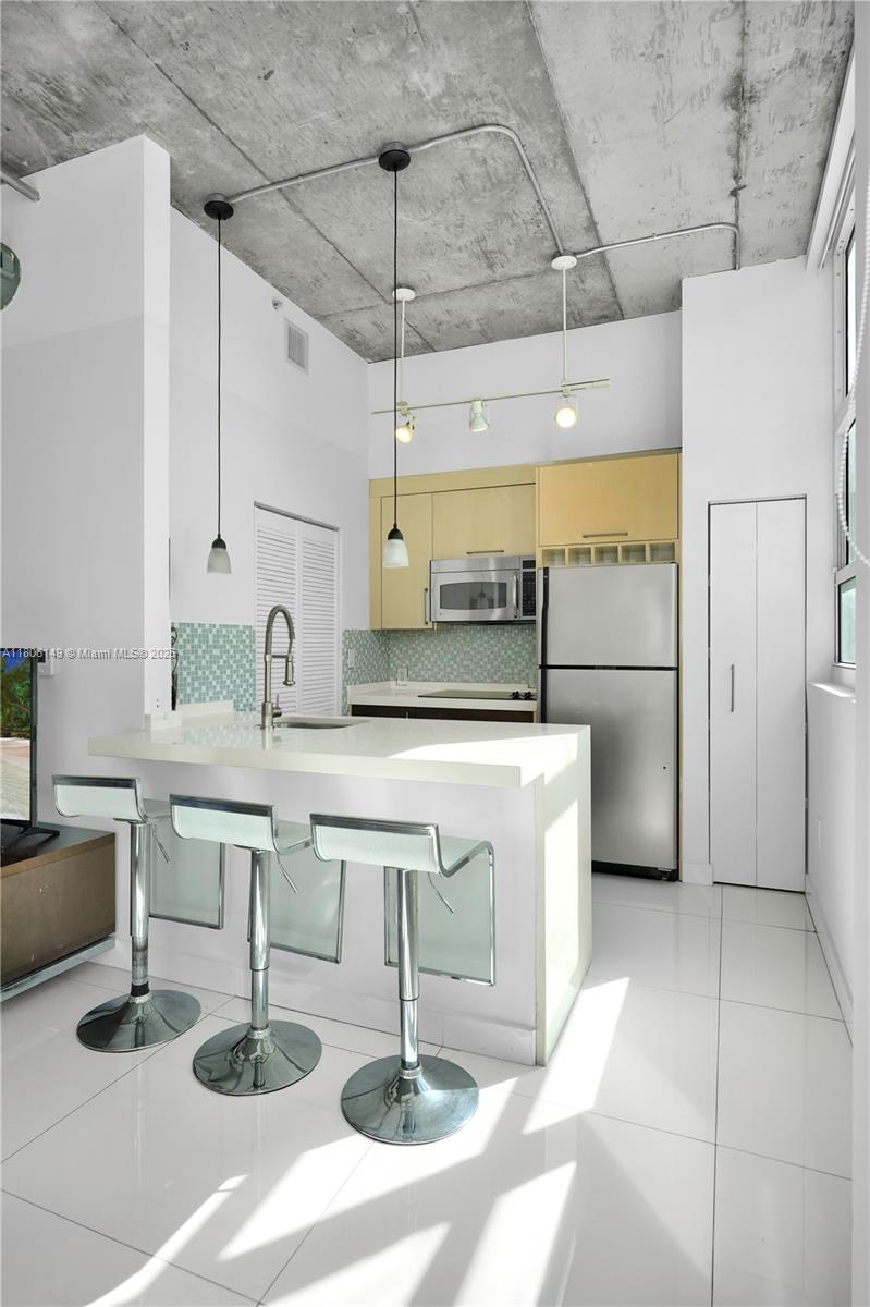 2001 Biscayne Boulevard, Unit 3213 Miami, FL 33137 - Photo 7 of 31 a kitchen with a sink a refrigerator and cabinets