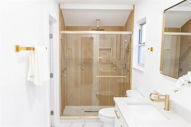 a bathroom with a sink a toilet and shower