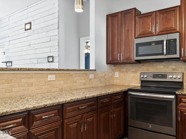 a kitchen with granite countertop cabinets stainless steel appliances and a sink