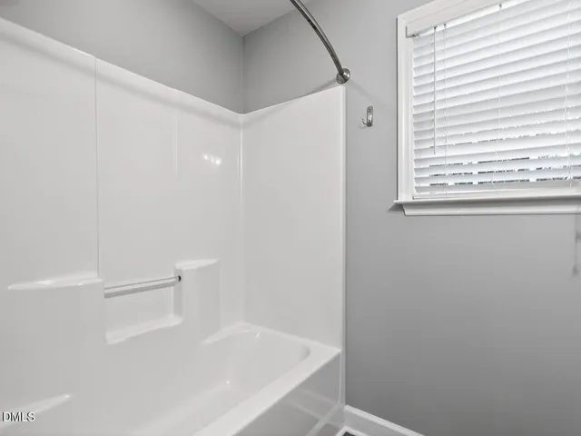 a bathroom with a bathtub and a window