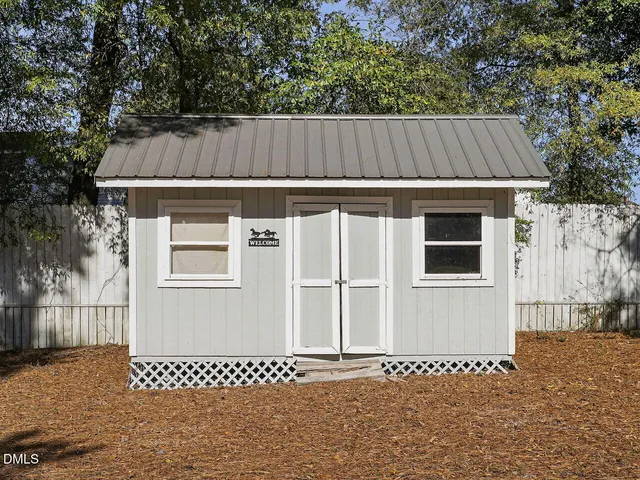a view of a house with a wooden fence