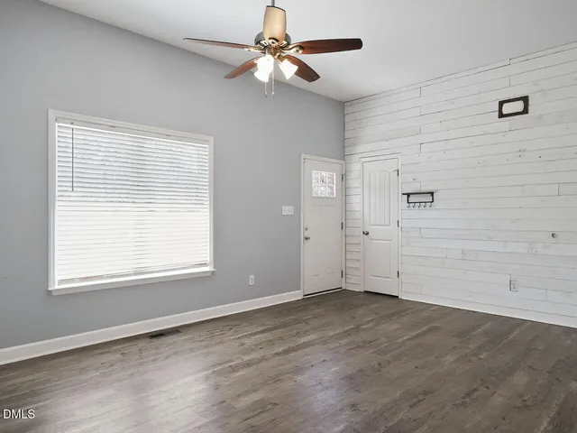 a view of an empty room with a window and a ceiling fan