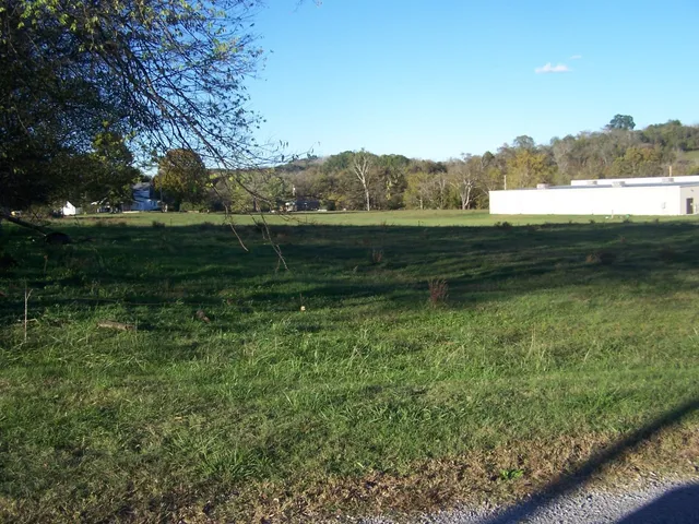 a view of a green field with wooden fence