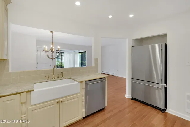 a kitchen with a refrigerator sink and cabinets