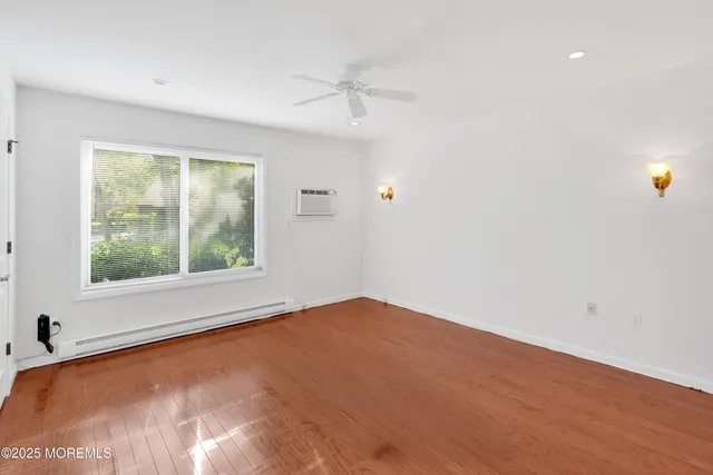 an empty room with a window and a ceiling fan