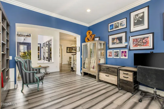a living room with furniture a piano and a bookshelf