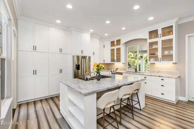 a kitchen with stainless steel appliances granite countertop a kitchen island sink refrigerator and cabinets