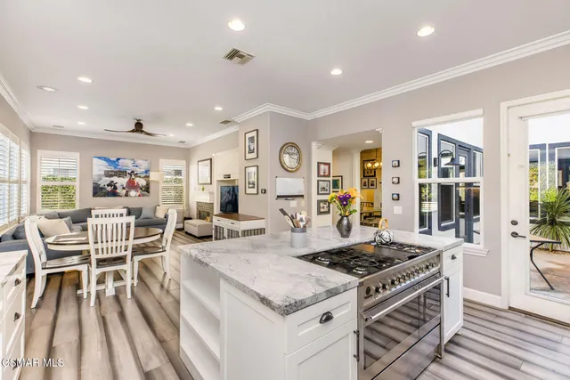 a open kitchen with stainless steel appliances granite countertop a stove and a view of living room