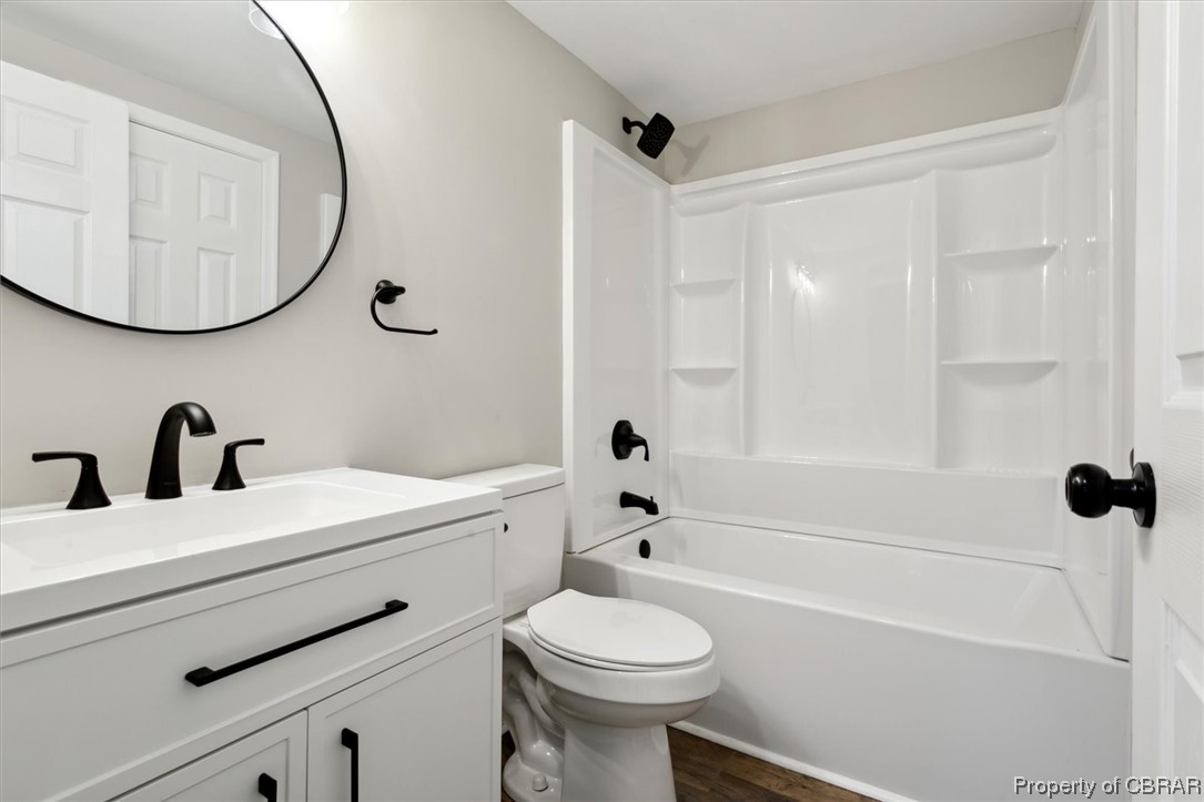 5684 Centerville Road Williamsburg, VA 23188 - Photo 19 of 33 Full bathroom with large vanity, hardwood / wood-style flooring, shower / bath combination, and toilet