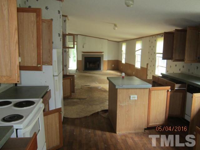 1492 Glenn Fogleman Road Rougemont, NC 27572 - Photo 11 of 24 a kitchen with granite countertop a sink a stove and a wooden cabinets