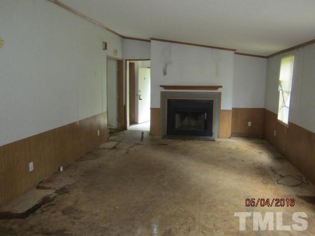 1492 Glenn Fogleman Road Rougemont, NC 27572 - Photo 9 of 24 an empty room with windows and fireplace