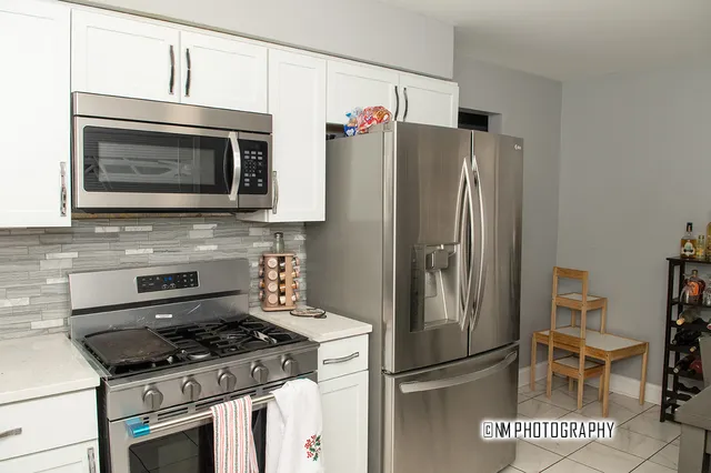 a kitchen with stainless steel appliances granite countertop a refrigerator stove and microwave