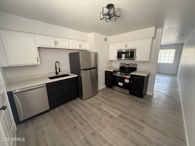 a kitchen with stainless steel appliances a refrigerator and a stove top oven