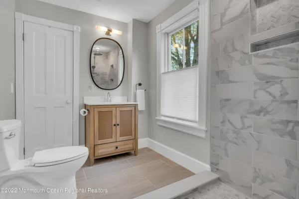 a bathroom with a toilet a sink and a window
