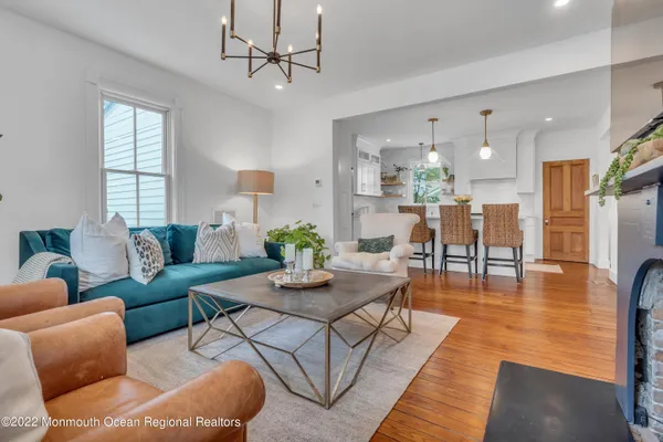 a living room with furniture wooden floor and a chandelier