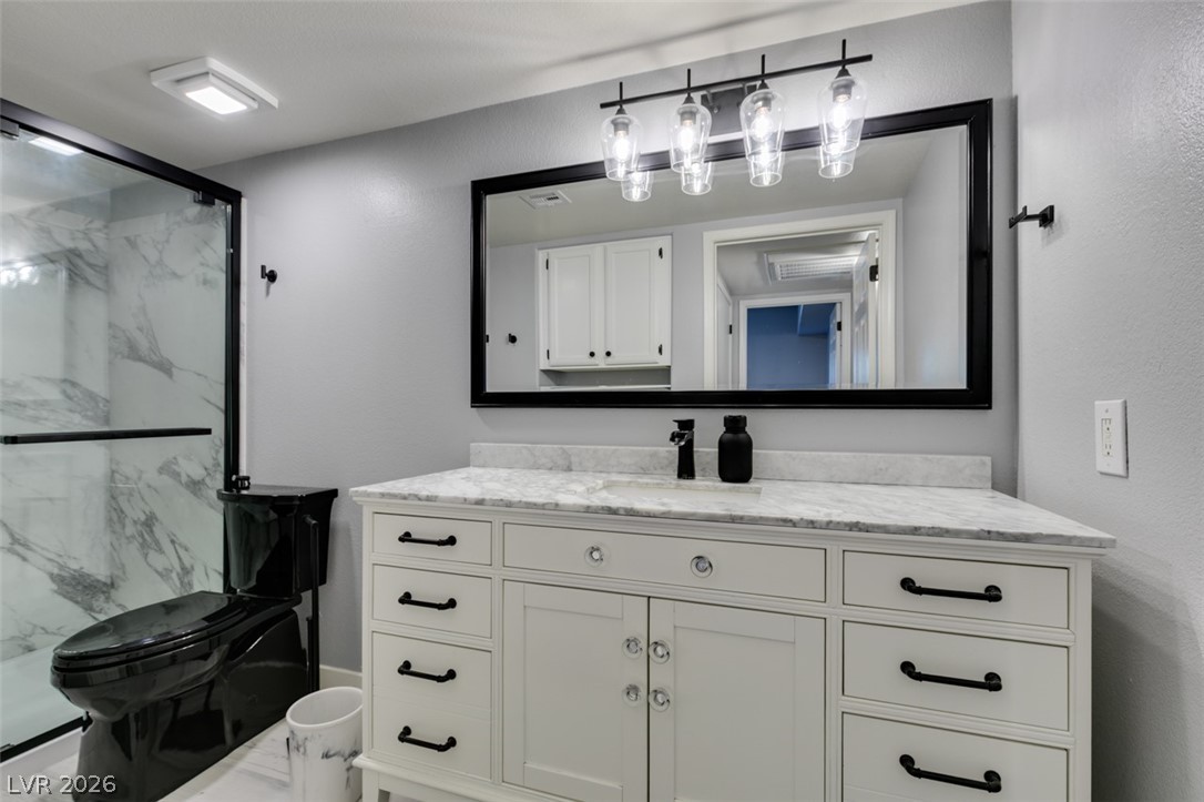 7255 West Sunset Road, Unit 1103 Las Vegas, NV 89113 - Photo 35 of 35 A well-appointed bathroom features a spacious vanity with marble counters and sleek fixtures.